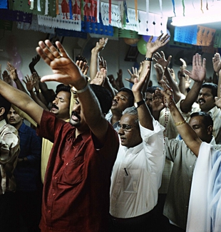 Immigrati dal Kerala (India) pregano nel garage di un villaggio dormitorio (Emirati Arabi Uniti, gennaio 2007, ©Fabio Proverbio)