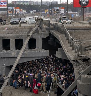 Irpin, 5 marzo 2022. Gli abitanti della cittadina ucraina sotto il ponte crollato in attesa di essere evacuati (©Emilio Morenatti/AP/La Presse)