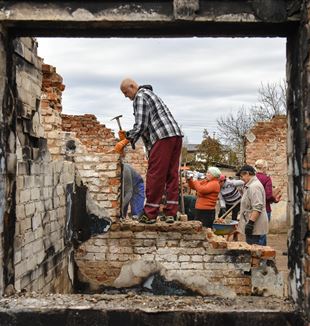 Volontari all'opera tra le macerie di un villaggio vicino a Chernihiv, in Ucraina (Foto Ansa)