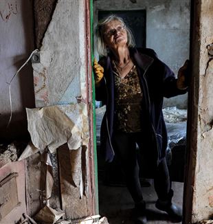 Una donna ucraina nella sua casa distrutta vicino a Kharkiv (Ansa)
