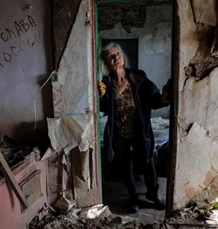 Una donna ucraina nella sua casa distrutta vicino a Kharkiv (Ansa)