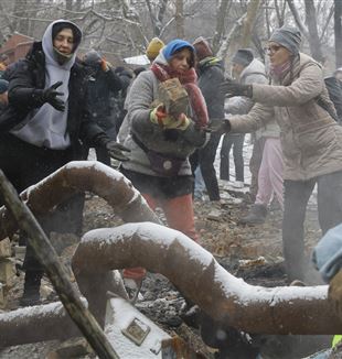 Kyiv, 3 gennaio 2024. Alcuni volontari rimuovono le macerie dopo un bombardamento (Foto: ANSA)