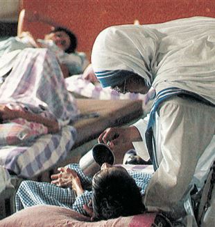 Le Suore Missionarie della Carità di Madre Teresa di Calcutta mentre assistono un malato in un ospedale da campo (Ansa-Sfor)